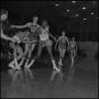 Photograph: [Basketball hangs in the air during a game]