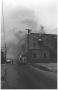 Primary view of [The Damron Hotel Fire, 9 of 21:   Firemen and a Fire Truck Near the North Side of Budiling]
