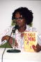 Photograph: [Camika Spencer holding her book, "He Had it Coming"]