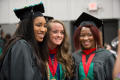 Photograph: [Three graduate students at commencement ceremony]