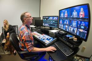Primary view of object titled '[NT Daily TV team member sitting at control board]'.