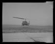 Primary view of [Photograph of a UH-1B Iroquois helicopter hovering just above the ground]