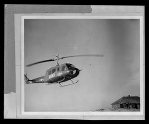 Primary view of object titled '[Photograph of a YUH-1D Iroquois helicopter in flight]'.