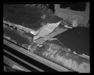Primary view of object titled '[Photograph of parts of a wrecked aircraft on a workbench]'.