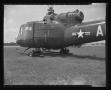 Photograph: [Photograph of a side view of a UH-1B Iroquois helicopter parked in a…