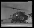 Primary view of [Photograph of a man climbing into a YUH-1D Iroquois helicopter]