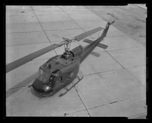 Primary view of object titled '[Photograph of a UH-1C Iroquois helicopter resting on a concrete surface]'.