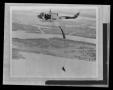 Photograph: [Photograph of an individual parachuting from a YUH-1D Iroquois helic…