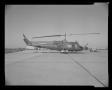 Photograph: [Photograph of a UH-1B Iroquois helicopter parked outdoors]
