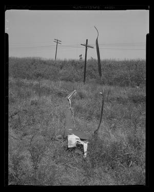 Primary view of object titled '[Photograph of parts of a wrecked aircraft in a field of tall grass]'.
