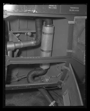 Primary view of object titled '[Photograph of flexible hoses and mechanical components inside a UH-1B Iroquois helicopter]'.
