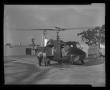 Photograph: [Photograph of individuals working on a YUH-1D Iroquois helicopter]