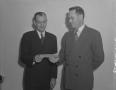 Photograph: [Two Men Holding a Paper Slip]