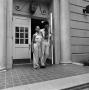 Photograph: [Two individuals exiting a building, 2]