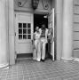 Photograph: [Two individuals exiting a building, 3]