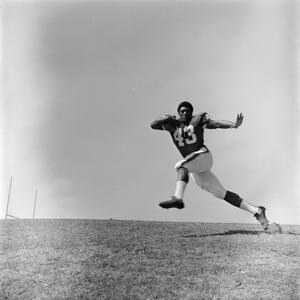 Primary view of [Football player #43, Bob Wyatt, sprinting across the field carrying the ball]