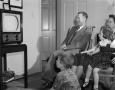 Photograph: [Man, woman, and two children watching TV]