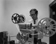 Photograph: [Tom McDonald with a film projector]