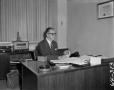 Photograph: [Roy Newman working at his desk]
