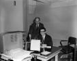 Photograph: [Photo of two men in an office]