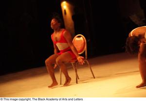 Primary view of [Photograph of a man dancing in a chair on stage]