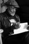 Photograph: [Photograph of Melvin Van Peebles signing a book]