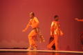 Photograph: [Photograph of two men standing on stage in orange clothing]