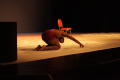 Photograph: [Photograph of a dancer kneeling down at the front of the stage]