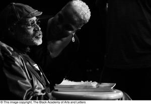 Primary view of object titled '[Photograph of Melvin Van Peebles with an unidentified woman on stage]'.