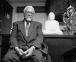 Primary view of [Dr. Donald A. Brooks seated with Buddha statue]