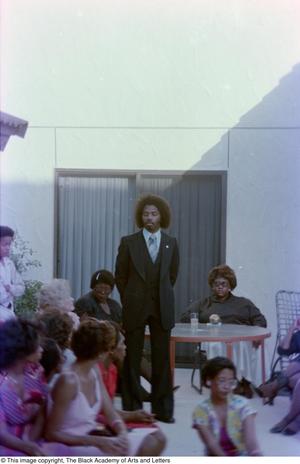 Primary view of object titled '[Photograph of Curtis King standing and looking down towards the crowd]'.