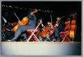 Photograph: [Photograph of cellists playing their instruments]