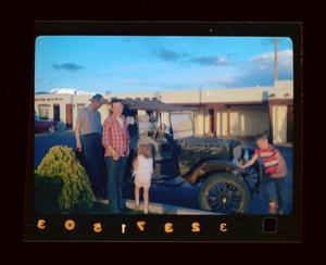 Primary view of object titled '[Photograph of Byrd Williams III, Tim, Pam, and Byrd Williams IV with a vintage automobile]'.