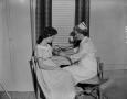 Photograph: [Nurse checking a woman's blood pressure]