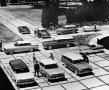 Photograph: [Cars and people gathered in a plaza]