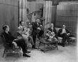Photograph: [Men on sitting in chairs on set]