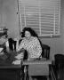 Photograph: [Woman sitting behind a typewriter]