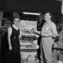 Photograph: [Man and woman standing in front of a store display at Lander Mercant…