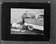 Photograph: [Woman putting luggage in a trunk]