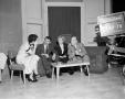 Photograph: [Ann Alden having a conversation with three guests]