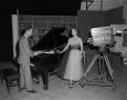 Photograph: [Photograph of a woman and WBAP-TV video camera]
