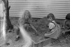 Primary view of object titled '[Photograph of two little girls playing in a sandbox]'.