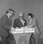 Photograph: [Three men behind a podium]