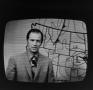 Photograph: [Man in front of a weather map]