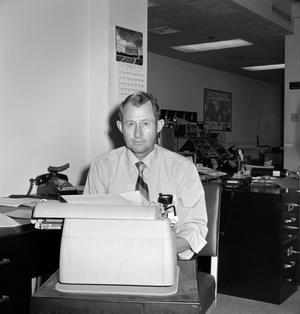 Primary view of object titled '[Clint Bourland using a typewriter]'.