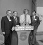 Photograph: [Four men behind a podium]
