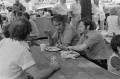 Photograph: [Men eating at a picnic table]