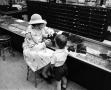 Photograph: [A women and a child at a store, 3]
