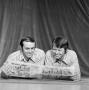 Photograph: [Kneisel and Kelley looking at a newspaper]