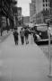Photograph: [Photograph of individuals walking down a sidewalk]